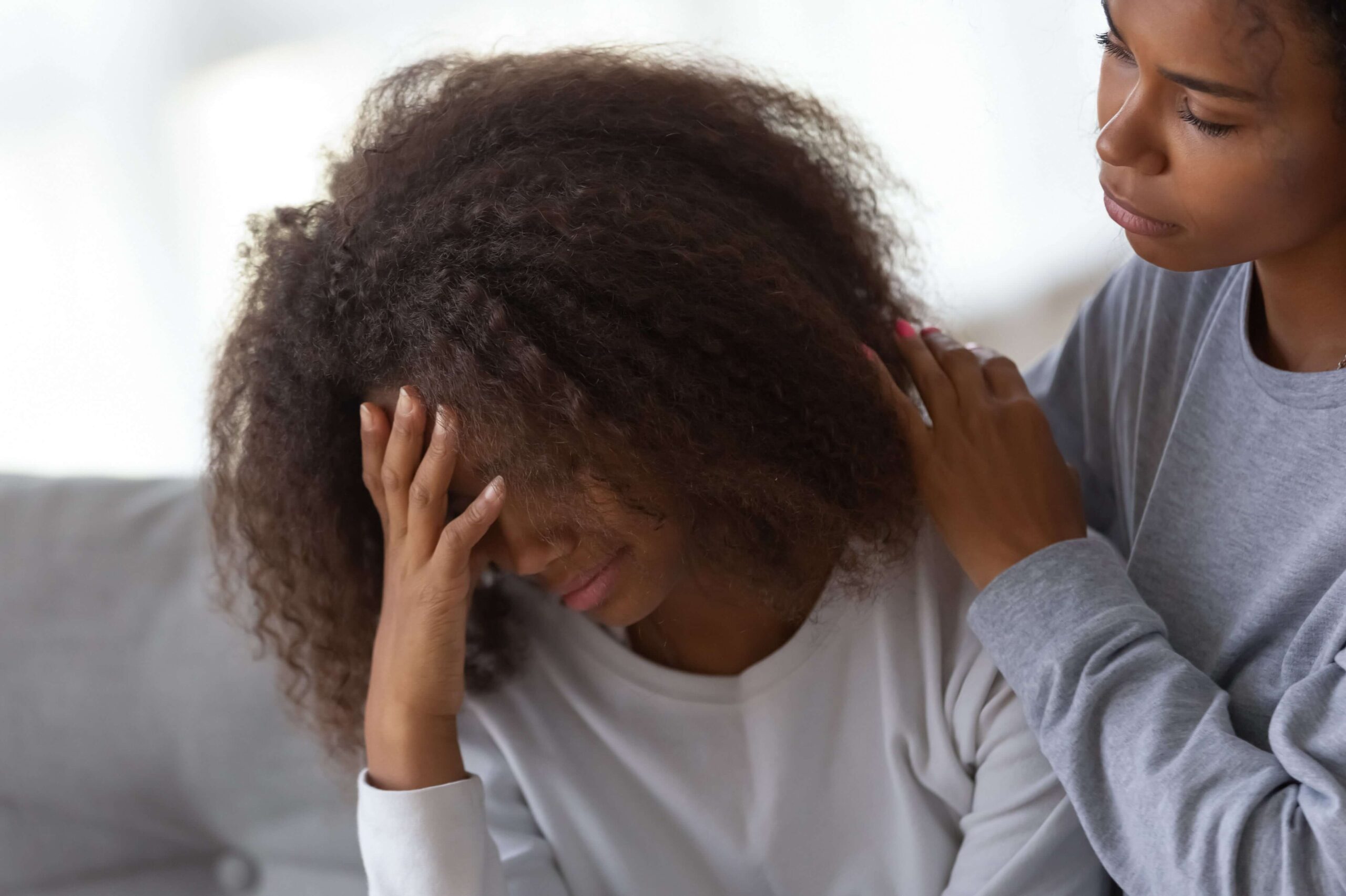 Young adult being comforted by a friend.